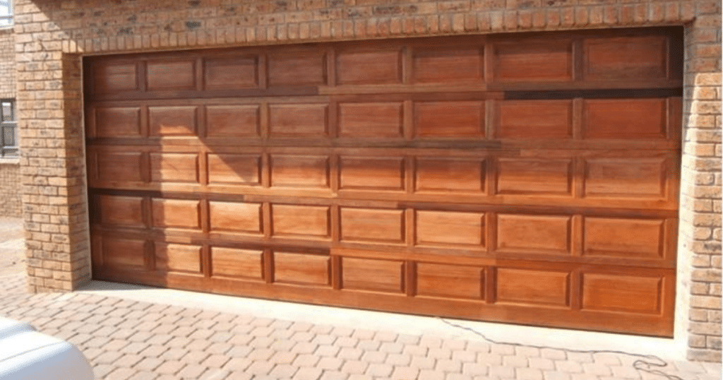 Wooden garage door with brick wall frame.
