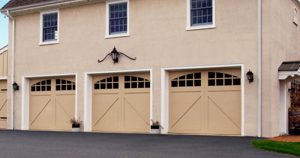 Tan garage doors with classic window trim.