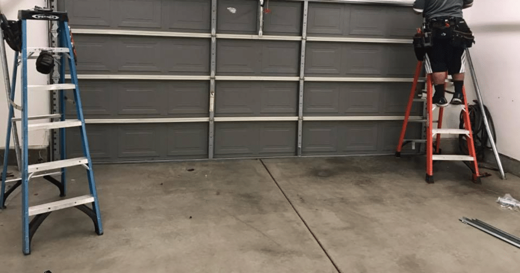 Garage door repair; ladders and tools set up.